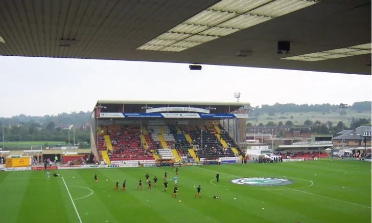 Các cầu thủ Lincoln City FC đang tập luyện hăng say trên sân Sincil Bank, chuẩn bị cho mùa giải bóng đá Anh, thể hiện tinh thần chuyên nghiệp của đội bóng The Imps.