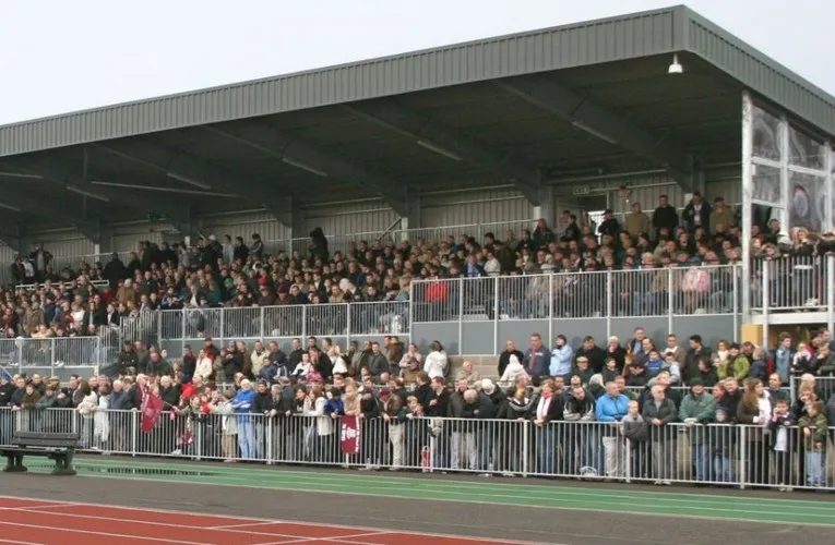 Hình ảnh người hâm mộ tại khán đài sân Melbourne Stadium Chelmsford, cho thấy không khí các trận đấu của Chelmsford City FC và trải nghiệm xem bóng đá tại đây.