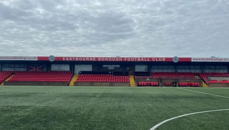 Khán đài chính (Main Stand) của sân Priory Lane với các hàng ghế trống và khung thành