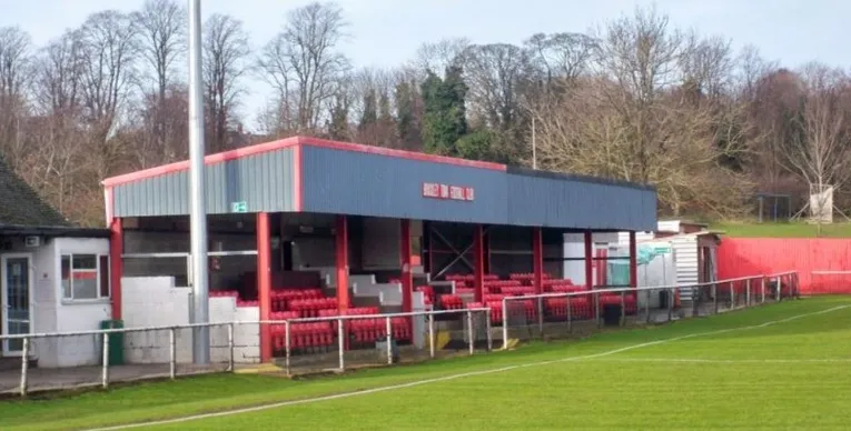 Khán đài trống tại sân St James Park, Brackley, cho thấy góc nhìn toàn cảnh về kiến trúc sân vận động nhỏ gọn.