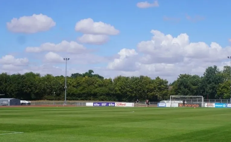 Khu vực sân cỏ và đường chạy điền kinh tại Melbourne Community Stadium Chelmsford, minh họa cấu trúc đa năng của sân nhà Chelmsford City FC, nơi diễn ra cả các trận đấu bóng đá và sự kiện thể thao khác.
