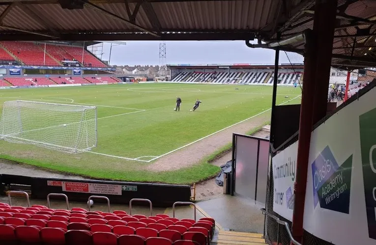 Khung cảnh sân Blundell Park nhìn từ khán đài, cho thấy mặt sân cỏ xanh mướt và các hàng ghế.