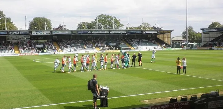 Khung cảnh trận đấu giữa Yeovil Town và Luton Town tại sân Huish Park, trải nghiệm khách VIP và khu vực hiếu khách.