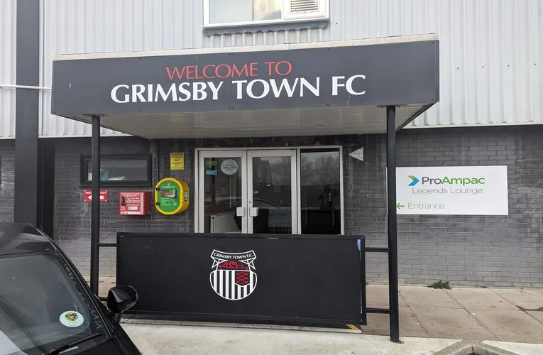 Lối vào chính của sân vận động Blundell Park, với kiến trúc cổ điển và bảng hiệu câu lạc bộ Grimsby Town.