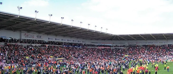 Người hâm mộ Blackpool FC cuồng nhiệt ăn mừng tại Bloomfield Road, khoảnh khắc đáng nhớ khi đội bóng giành quyền tham dự trận play-off năm 2010, thể hiện niềm đam mê bóng đá Anh.