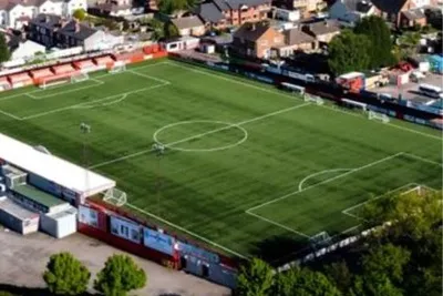 Tổng quan sân vận động The Lamb Ground của Tamworth FC với khán đài và sân cỏ 3G.
